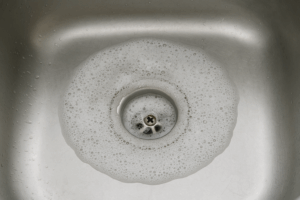 Close-up of a slow-draining sink with hair and soap residue, highlighting plumbing issues Close-up of a slow-draining sink with hair and soap residue, highlighting plumbing issues